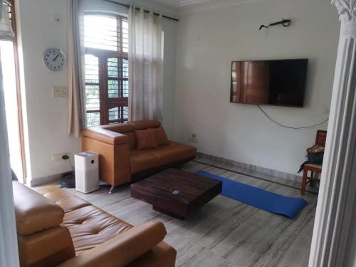 een woonkamer met een bank en een tv bij Long An Guest Rooms in Tân An
