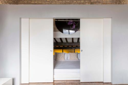 1 dormitorio con puertas blancas que conducen a una cama en Monti apartment BDB, en Roma