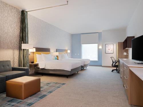 Habitación de hotel con cama y sofá en Home2 Suites By Hilton Atlanta Airport College Park, en Atlanta