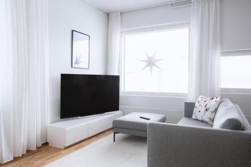 un soggiorno con TV e divano di Nordic Design Apartment City Center a Rovaniemi