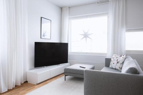 a living room with a tv and a couch at Nordic Design Apartment City Center in Rovaniemi