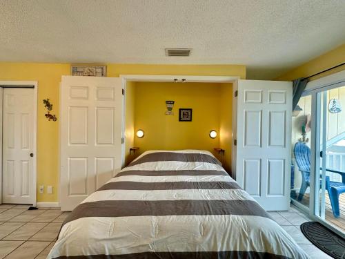 a bedroom with a bed and a yellow wall at Sandpiper Cove 8115 in Destin