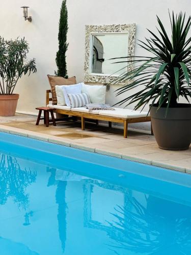 - un canapé installé à côté d'une piscine avec un miroir dans l'établissement Beautiful and spacious 3 bed character home with large, private heated pool, à Pouzolles