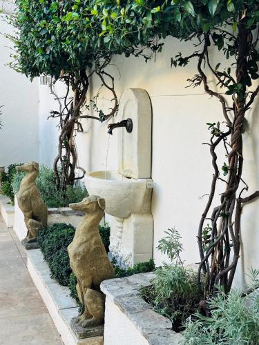 une fontaine avec deux statues d'ours dans un jardin dans l'établissement Beautiful and spacious 3 bed character home with large, private heated pool, à Pouzolles