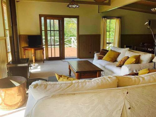 a living room with a couch and a table at Rivendell Cottage in Steels Creek
