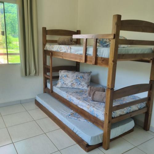 a room with three bunk beds in a room at Casa no Sítio in Penha