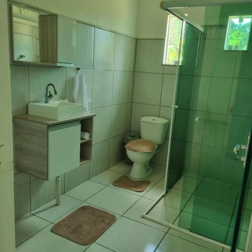 uma casa de banho com um chuveiro, um WC e um lavatório. em Casa no Sítio em Penha