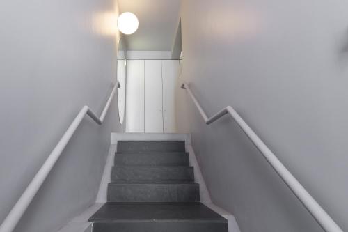 a staircase leading up to a room with white walls at QP Trindade Apartments in Porto