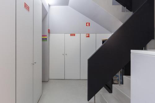 a hallway with white cabinets and a black staircase at QP Trindade Apartments in Porto