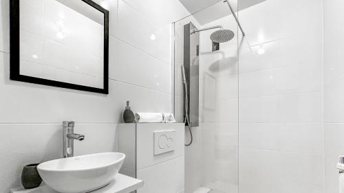ein weißes Bad mit einem Waschbecken und einer Dusche in der Unterkunft VELVET - Proche Genève - Au pied du Tram - Wifi Gratuit in Ambilly
