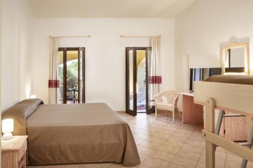 um quarto de hotel com uma cama e uma secretária e um quarto em Hotel Sole Mare em Baja Sardinia