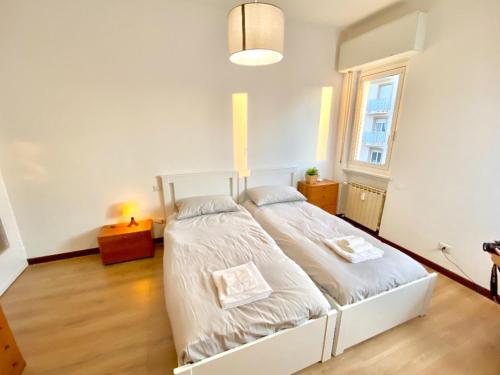 een slaapkamer met een wit bed in een kamer bij Duomo a 15 minuti - Lussuoso appartamento in Milaan