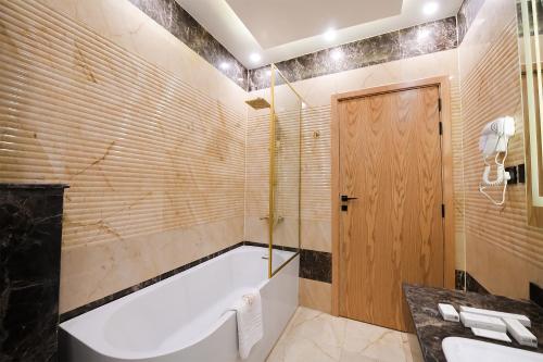a bathroom with a tub and a sink at Arabella Premium Residence - New Cairo in Cairo