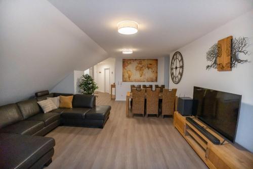 High-quality renovated apt (TLA/Tlf/TDY-RAB) في رامشتاين-ميزنباخ: غرفة معيشة مع أريكة وتلفزيون بشاشة مسطحة