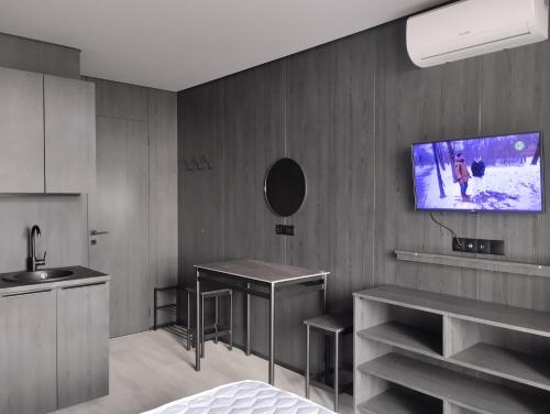 cocina con TV colgada en la pared en Номер-студіо "Міні Феофанія" Заболотного 148, Кришталеві Джерела, лікарня, пораненим воїнам -10", en Kiev