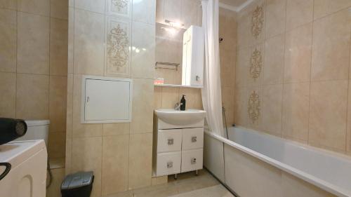 a bathroom with a sink and a tub and a toilet at 19 2х комн с 2 мя кроватями и раскладной диван,2 санузла 1- 6 человек,возле Байтерека in Astana