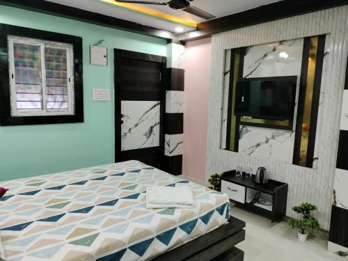 Schlafzimmer mit einem Bett und einem Flachbild-TV in der Unterkunft Hotel sweta villa & banquet hall in Bankipur