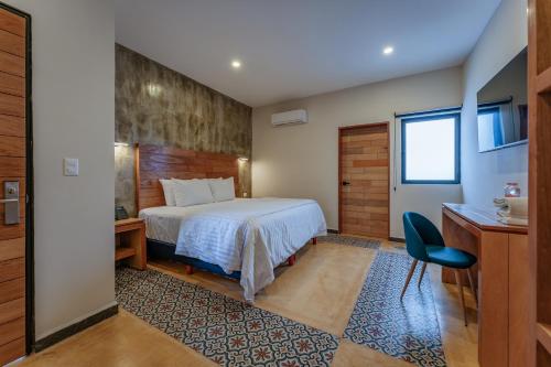 Habitación de hotel con cama y escritorio en Hotel Casa 57 en Mérida