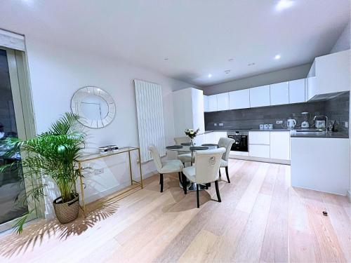 a kitchen and dining room with a table and chairs at Stylish Apartment Docklands in London