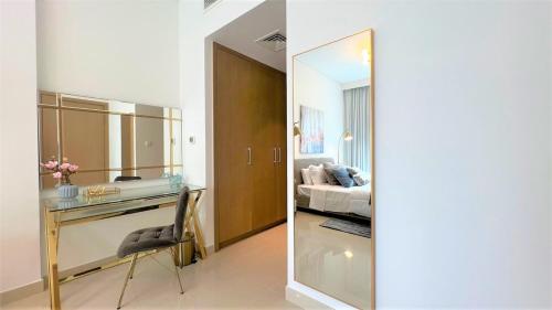 a room with a desk and a bed and a mirror at Luxurious Creek Harbour Apt with Balcony & View in Dubai