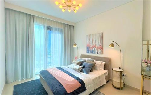 a bedroom with a bed and a large window at Luxurious Creek Harbour Apt with Balcony & View in Dubai
