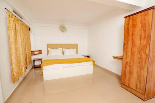 1 dormitorio con 1 cama y puerta de madera en EL LORA RESlDENCY, en Munnar