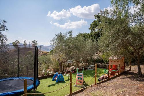 a park with a playground with slides and swings at Casetta Pizziddu in San Giovanni Gemini