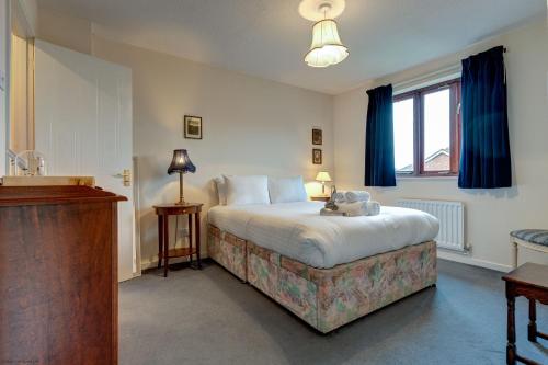 1 dormitorio con 1 cama grande y cortinas azules en Sparrows Nest, en Oxford