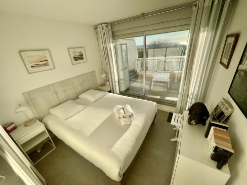 une chambre avec un lit et un balcon dans l'établissement PGH N25 - Vue Mer, Première Ligne & Parking Privé, à La Grande Motte