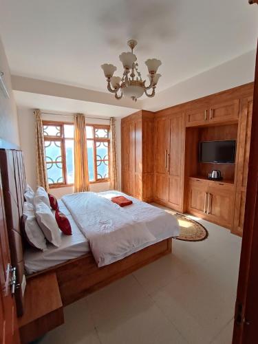 a bedroom with a large bed and a chandelier at Snowline Homestay in Kīar