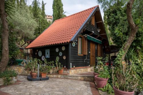 a small black house with an orange roof at Casetta Pizziddu in San Giovanni Gemini
