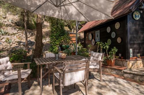 a wooden table and chairs under an umbrella at Casetta Pizziddu in San Giovanni Gemini