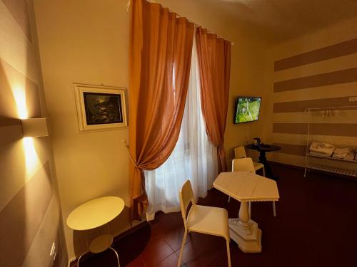フィレンツェにあるB&B Dante Alighieriのテーブルと窓が備わる小さな客室です。