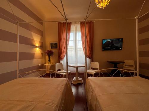 フィレンツェにあるB&B Dante Alighieriのベッド2台と窓が備わるホテルルームです。