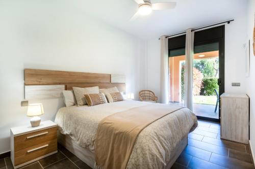 a bedroom with a large bed and a sliding glass door at Fabulous GREEN 19 entre mar y montaña in Bonmont Terres Noves