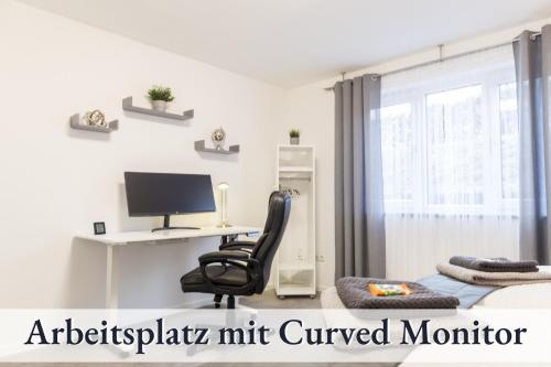 1 dormitorio con escritorio, silla y ordenador en RelaxApartment 15 Massagesessel SmartTV Küche, en Biberach an der Riß