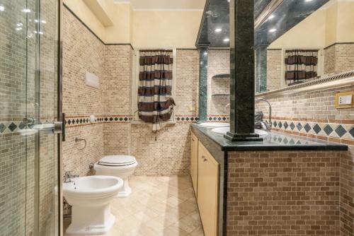 ein Bad mit einem WC und einem Waschbecken in der Unterkunft Appartamento in villa con piscina in Palermo