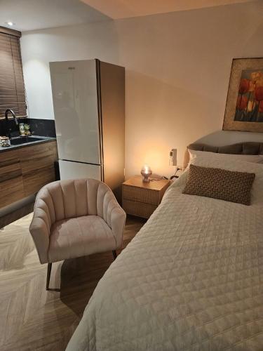 1 dormitorio con cama, silla y lavamanos en יחידת סאן סנטר באילת en Eilat