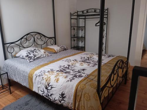 - une chambre dotée d'un lit avec un cadre en fer forgé dans l'établissement le petit st jacques, à Cognac