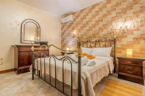 Schlafzimmer mit einem Bett und einem Spiegel in der Unterkunft Appartamento in villa con piscina in Palermo