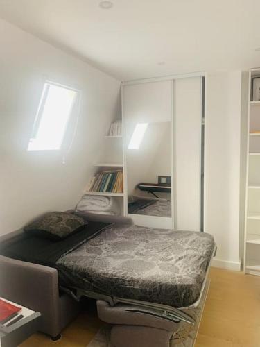 a bedroom with a bed in the corner of a room at Studio cosy au cœur de Paris in Paris