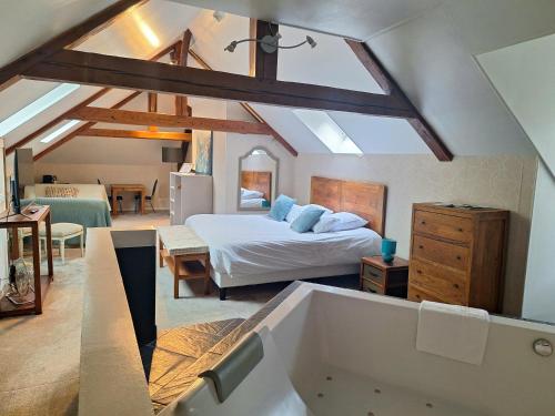 a bedroom with a bed and a tub in a room at Domaine de Joinville in Eu