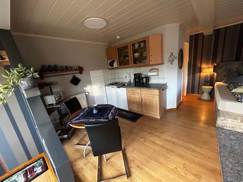 een kleine keuken en een woonkamer met een tafel en stoelen bij Partzsch Apartment in Wethau