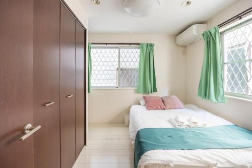 a bedroom with two beds and green curtains at CROWN 海辺 in Tokyo