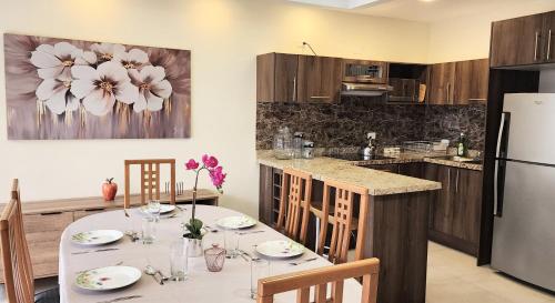 a kitchen with a dining table and a refrigerator at Grandioso Apartamento. in Quito