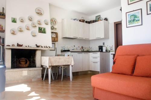 AcquaseriaにあるAnMa Cottages Sole Lagoのキッチン(ソファ、テーブル、暖炉付)