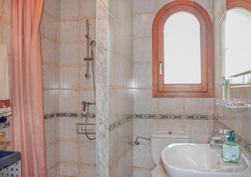 a bathroom with a sink and a toilet and a window at La Ardilla by dracmallorca in Cala Santanyi