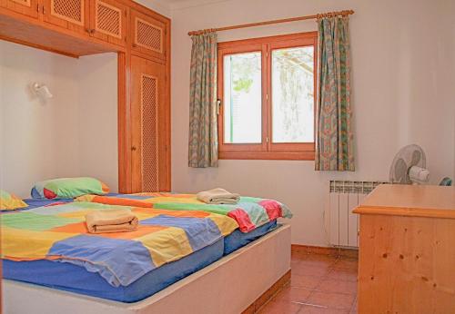 1 dormitorio con 2 camas y ventana en La Ardilla, en Cala Santanyi