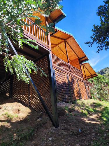 a tree house with a fence around it at Cabinas El Quetzal in San Gerardo de Dota