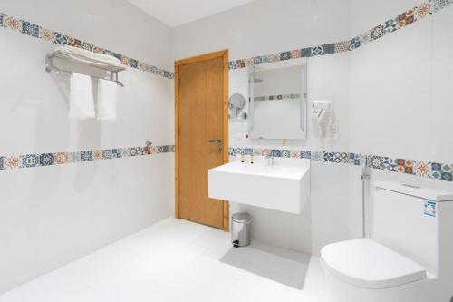 La salle de bains blanche est pourvue de toilettes et d'un lavabo. dans l'établissement براديس لاقون شهد الاريج 4 غرف بمسبح خاص, à Durat Alarous
